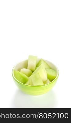 green melon in bowl. shopped green melon in bowl on white background