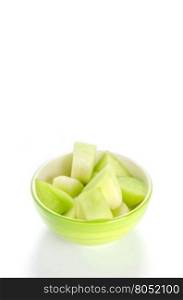 green melon in bowl. shopped green melon in bowl on white background