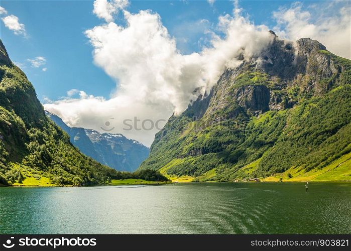 Green mountain peak above the small village in Naeroy fjord, Aurlan, Sogn og Fjordane county, Norway
