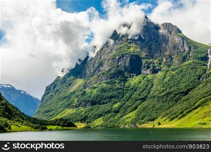 Green mountain peak above the small village in Naeroy fjord, Aurlan, Sogn og Fjordane county, Norway