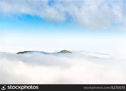 Green mountain peak in the ocean of clouds
