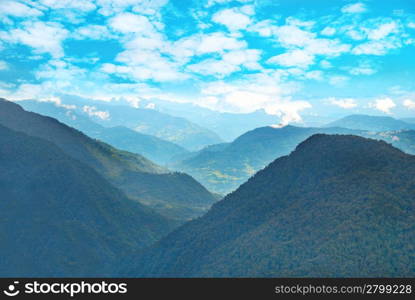 Green mountains with forest and blue cloudy sky