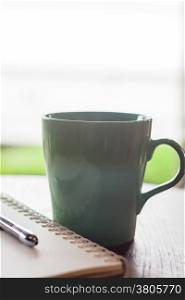 Green mug in coffee shop, stock photo