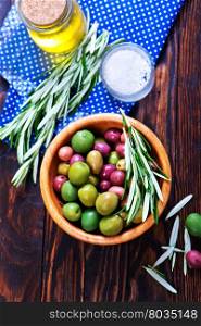 green olives in bowl and on a table