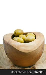 green olives in bowl on wooden plate close up isolated on white background
