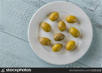 Green olives on the white plate
