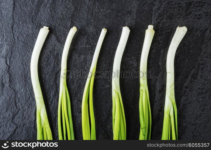 Green onions on a black stone table