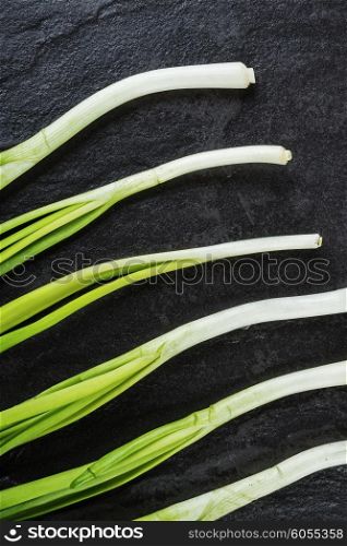 Green onions on a black stone table