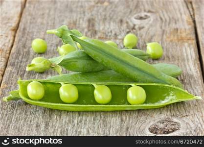 green organic peas on the wooden background