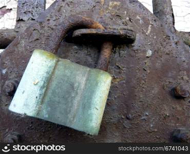green padlock. old green padlock on a rusty door