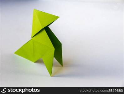 Green paper hen origami isolated on a blank white background. Cocotte en papier. Green paper hen origami isolated on a white background