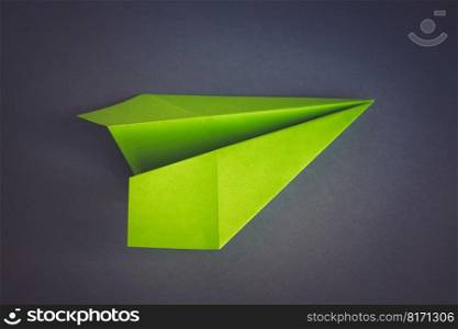 Green paper plane origami isolated on a blank grey background. Green paper plane origami isolated on a grey background