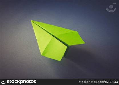 Green paper plane origami isolated on a blank grey background. Green paper plane origami isolated on a grey background