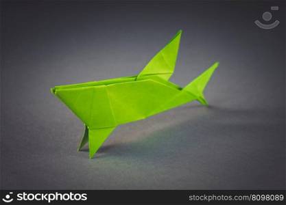Green paper shark origami isolated on a blank grey background. Green paper shark origami isolated on a grey background