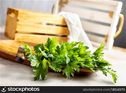 green parsley on wooden plate on a table
