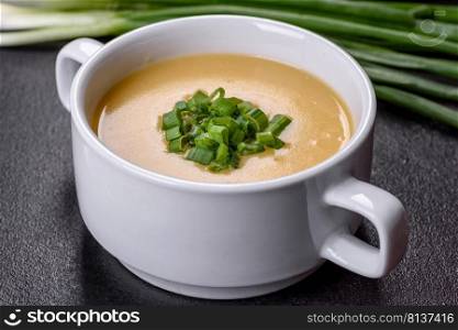 Green pea cream soup with crackers. Ve≥tarian hea<hy soup. Cream soup with potatoes,≤ek and peas on a dark concrete tab≤