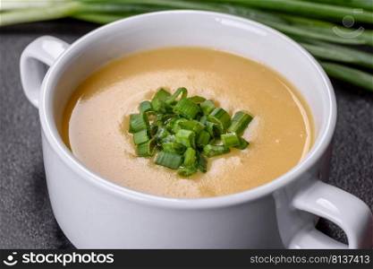 Green pea cream soup with crackers. Vegetarian healthy soup. Cream soup with potatoes, leek and peas on a dark concrete table