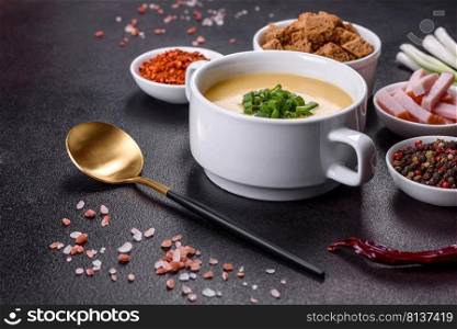 Green pea cream soup with crackers. Vegetarian healthy soup. Cream soup with potatoes, leek and peas on a dark concrete table