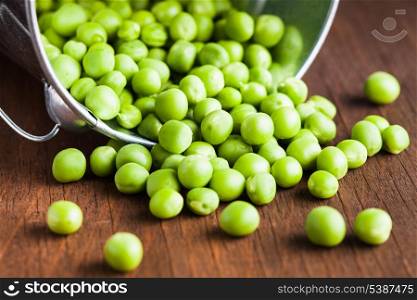 Green pea scattered on the wooden table