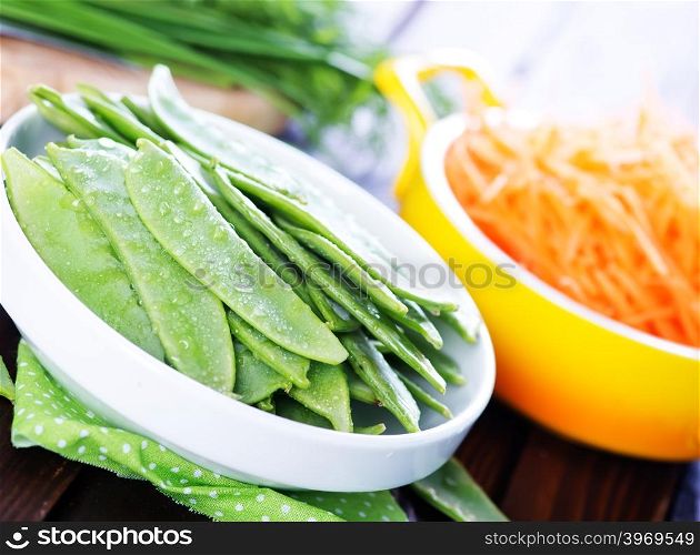 green peas in bowl and on a table