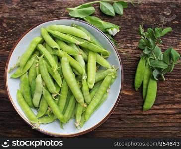 Green peas in bowl on wooden table background. Top view .. Green peas in bowl on wooden table background. Top view