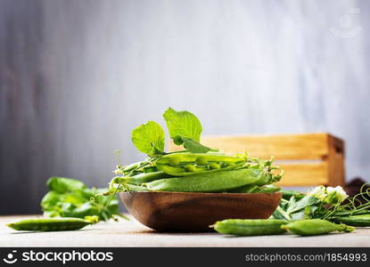 green peas in wooden bowl on a table