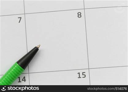 Green pen is placed on the calendar in the 8th day and have copy space for design in your work concept.