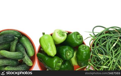 green peppers, cucumbers and garlic in a bowl isolated on white background