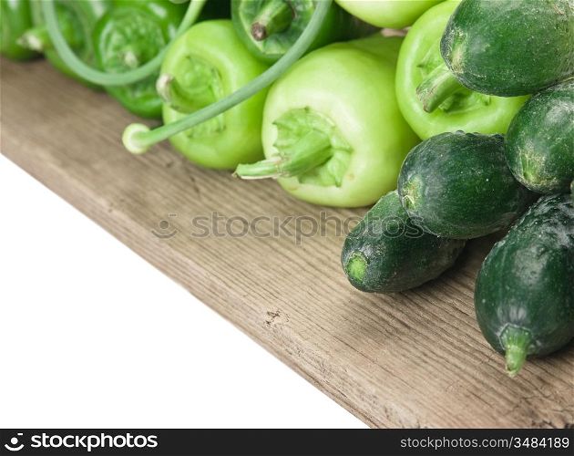 green peppers, cucumbers and garlic on a wooden table
