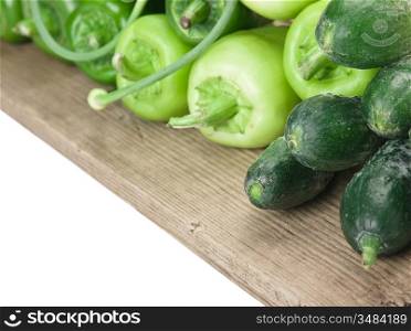 green peppers, cucumbers and garlic on a wooden table