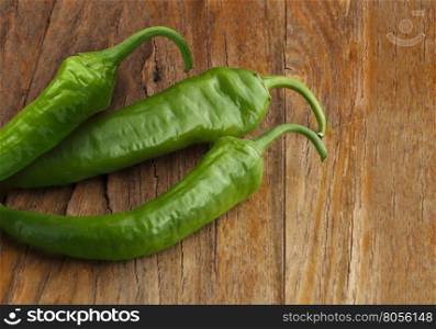 Green peppers on wood background