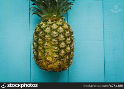 Green pineapple on a blue wooden table