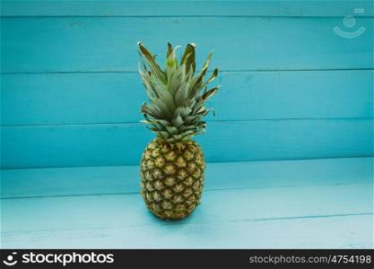 Green pineapple on a blue wooden table