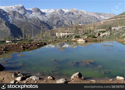 Green pond and house in mountain near Damavand volcano in Iran