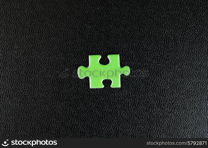 Green puzzles on a black leather background