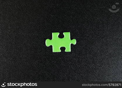 Green puzzles on a black leather background