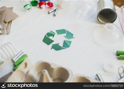 green recycle symbol surrounded with waste items