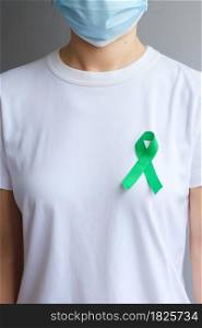 green Ribbon for Liver, Gallbladders, bile duct, cervical, kidney Cancer and Lymphoma Awareness month. Healthcare and world cancer day concept