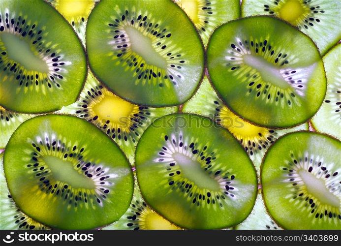Green ripe kiwi macro sliced cuts background