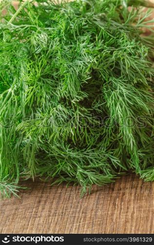 Green ripe organic dill on wooden background
