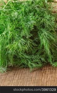 Green ripe organic dill on wooden background
