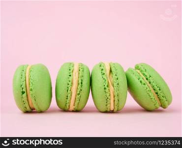 green round baked macaroon macarons on a pink background, delicious popular french dessert