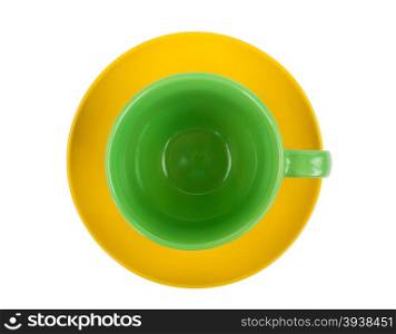 Green round empty tea cup on a yellow saucer