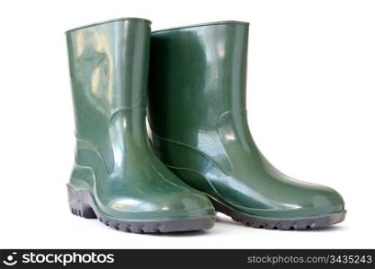 Green rubber boots over a white background