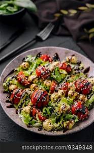 Green salad made with tomatoes, cheese mozzarella balls and sesame on plate