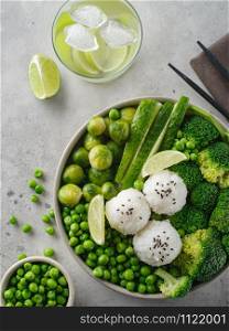 Green salad with rice and vegetables. Salad with lemon, cucumber, peas and broccoli. Top view