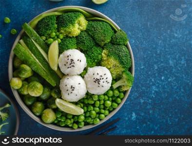 Green salad with rice and vegetables. Salad with lemon, cucumber, peas and broccoli. Top view