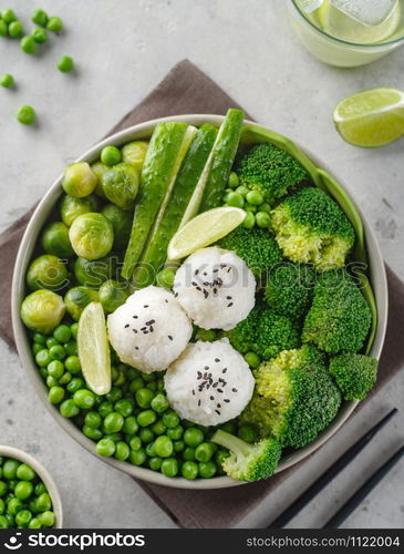 Green salad with rice and vegetables. Salad with lemon, cucumber, peas and broccoli. Top view