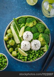 Green salad with rice and vegetables. Salad with lemon, cucumber, peas and broccoli. Top view