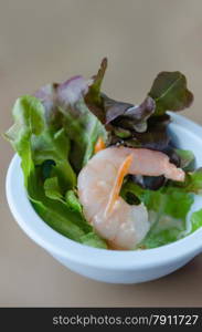 green salad with shrimp. Oak leaf lettuce salad with shrimps in blue bowl